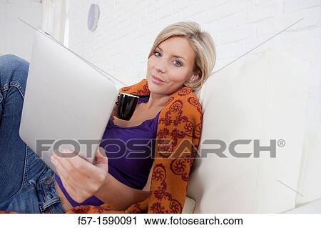 Woman relaxing on her bed with her tablet computer View Large Photo Image Stock Image - Woman relaxing on her bed with her tablet computer. Fotosearch