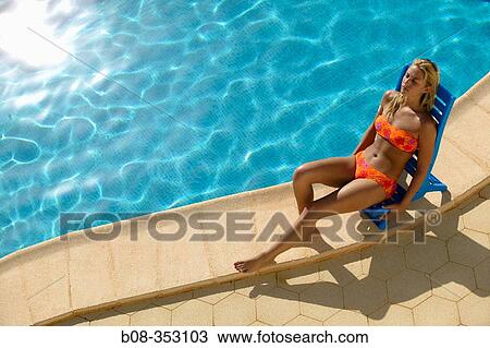 Stock Image - Woman relaxing on the swimming pool. Fotosearch