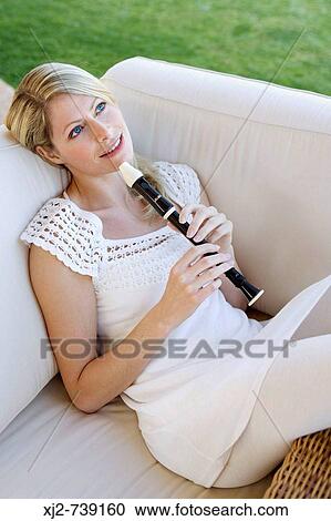 Woman relaxing with a flute in the terrace View Large Photo Image Stock Image - Woman relaxing with a flute in the terrace. Fotosearch