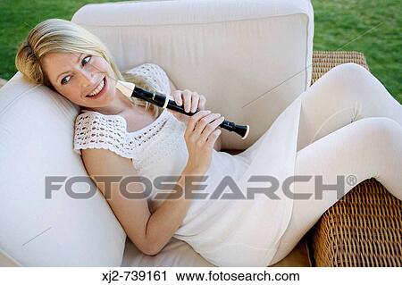 Woman relaxing with a flute in the terrace View Large Photo Image Stock Image - Woman relaxing with a flute in the terrace. Fotosearch