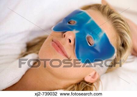 Stock Image - Woman relaxing with eye mask. Fotosearch
