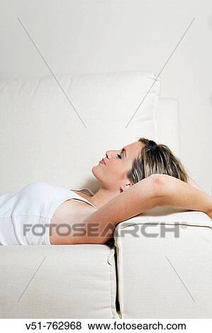 Stock Photo - Woman, resting, book, home, happy, leisure, lie down. Fotosearch