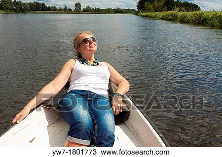 Woman resting in fishing boat on Narew river, Poland View Large Photo Image Stock Image - Woman resting in fishing boat on Narew river, Poland. Fotosearch