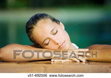 Woman resting on a pool's deck View Large Photo Image Stock Photograph - Woman resting on a pool's deck. Fotosearch