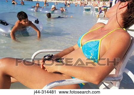 Woman resting on beach chair at the beach, Bahamas View Large Photo Image Stock Image - Woman resting on beach chair at the beach, Bahamas. Fotosearch