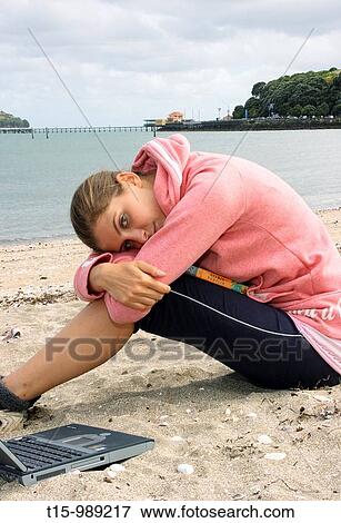 Woman resting on beach with laptop nearby View Large Photo Image Stock Photo - Woman resting on beach with laptop nearby. Fotosearch