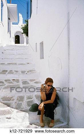 Stock Photo - Woman resting on the street, Parikia, Paros. Cyclades, Greece. Fotosearch