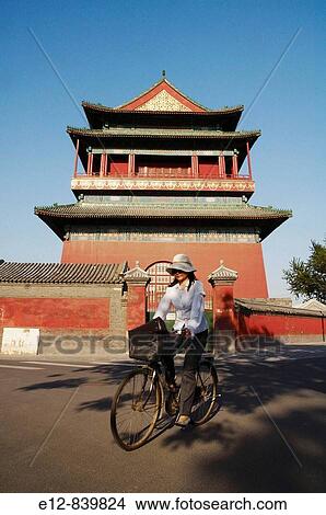 Woman riding bicycle in front of Gulou drum tower, Beijing. China View Large Photo Image Picture - Woman riding bicycle in front of Gulou drum tower, Beijing. China. Fotosearch