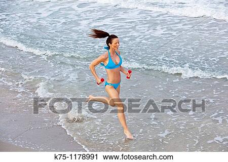 woman running along water's edge View Large Photo Image Stock Image - woman running along water's edge. Fotosearch