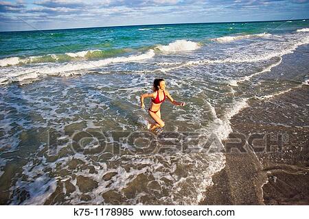woman running in incoming waves View Large Photo Image Stock Photography - woman running in incoming waves. Fotosearch