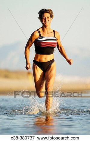Woman running on beach View Large Photo Image Stock Photo - Woman running on beach. Fotosearch
