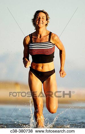 Stock Photo - Woman running on beach. Fotosearch