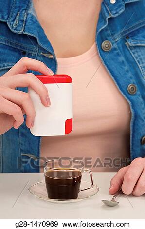 woman? s hands putting Aspartam sweetener into a cup of coffee View Large Photo Image Stock Photo - woman? s hands putting Aspartam sweetener into a cup of coffee. Fotosearch