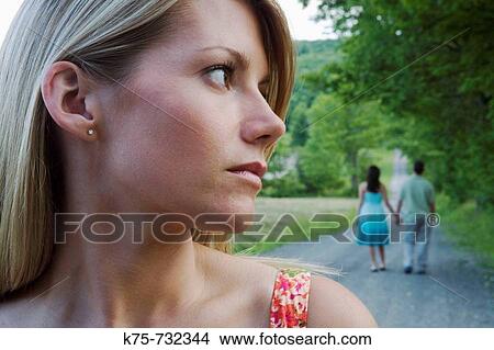 Woman sad to see her boyfriend with another woman View Large Photo Image Picture - Woman sad to see her boyfriend with another woman. Fotosearch