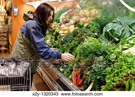 Woman shopping for organic vegetables in a market View Large Photo Image Stock Image - Woman shopping for organic vegetables in a market. Fotosearch