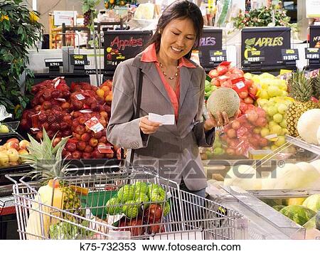 Stock Image - Woman shopping for produce. Fotosearch
