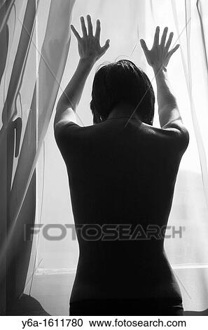 Woman silhouetted against window light placing hands on window View Large Photo Image Stock Image - Woman silhouetted against window light placing hands on window. Fotosearch
