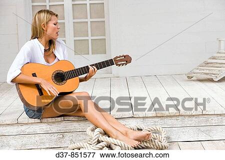 Woman singing and playing guitar View Large Photo Image Stock Photo - Woman singing and playing guitar. Fotosearch