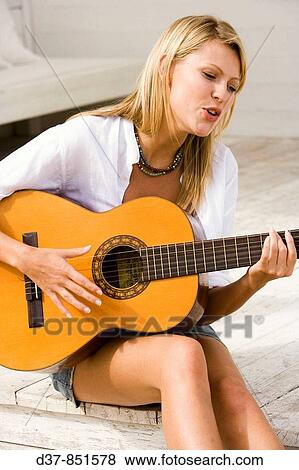 Woman singing and playing guitar View Large Photo Image Stock Photo - Woman singing and playing guitar. Fotosearch