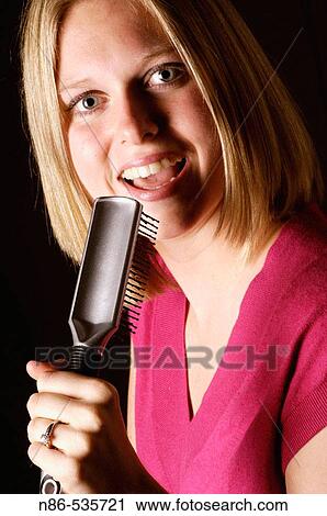 Woman singing into hair brush View Large Photo Image Stock Image - Woman singing into hair brush. Fotosearch