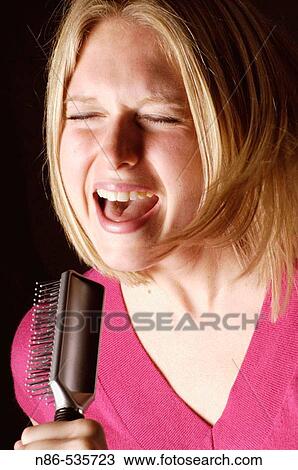 Woman singing into hair brush View Large Photo Image Stock Image - Woman singing into hair brush. Fotosearch