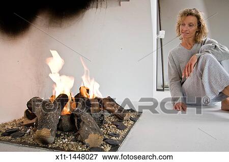 Woman sitting by fireplace View Large Photo Image Stock Photo - Woman sitting by fireplace. Fotosearch