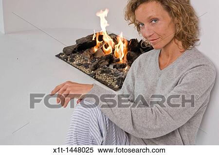 Woman sitting by fireplace View Large Photo Image Stock Photography - Woman sitting by fireplace. Fotosearch