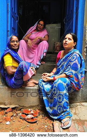 Stock Image - Woman sitting by the quiet back street in the old town. Fotosearch