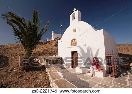 Woman sitting in front of a chapel at the top of the hill in Chora, Ios, Cyclades Islands, Greek Islands, Greece, Europe. View Large Photo Image Stock Photography - Woman sitting in front of a chapel at the top of the hill in Chora, Ios, Cyclades Islands, Greek Islands, Greece, Europe.. Fotosearch