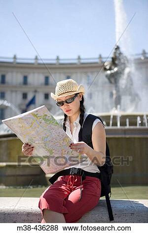 Woman sitting in front of a fountain reading a map. Rome, Italy. View Large Photo Image Stock Photo - Woman sitting in front of a fountain reading a map. Rome, Italy.. Fotosearch