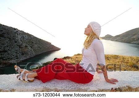 Woman sitting in Galissa beach, Galissa, Syros island, Greek Island, Cyclades, Greek, Europe View Large Photo Image Picture - Woman sitting in Galissa beach, Galissa, Syros island, Greek Island, Cyclades, Greek, Europe. Fotosearch