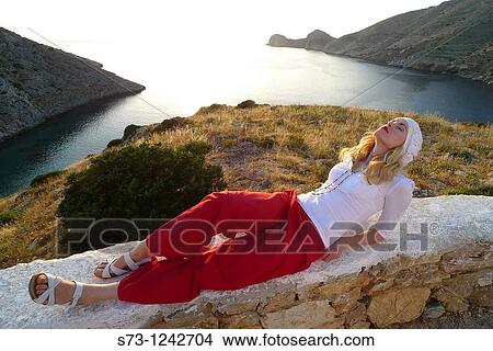 Woman sitting in Galissa beach, Galissa, Syros island, Greek Island, Cyclades, Greece, Europe View Large Photo Image Picture - Woman sitting in Galissa beach, Galissa, Syros island, Greek Island, Cyclades, Greece, Europe. Fotosearch