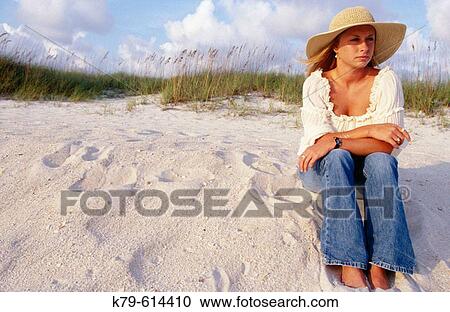 Woman sitting in sand dunes gazing off into the distance. View Large Photo Image Stock Image - Woman sitting in sand dunes gazing off into the distance.. Fotosearch