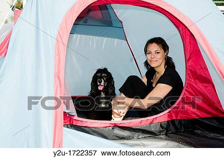 Woman sitting inside a tent with her cocker spaniel dog View Large Photo Image Stock Photo - Woman sitting inside a tent with her cocker spaniel dog. Fotosearch