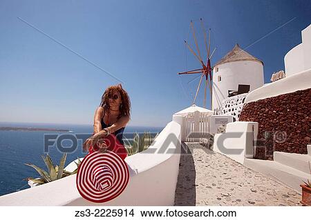 Woman sitting near a windmill, Oia town, Santorini, Cyclades Islands, Greek Islands, Greece, Europe. View Large Photo Image Picture - Woman sitting near a windmill, Oia town, Santorini, Cyclades Islands, Greek Islands, Greece, Europe.. Fotosearch