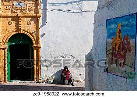 Woman sitting next to a beautiful moroccan door in Azemmour medina, Morocco. View Large Photo Image Stock Image - Woman sitting next to a beautiful moroccan door in Azemmour medina, Morocco.. Fotosearch