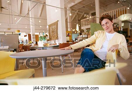 Woman sitting on a chair in a furniture store View Large Photo Image Stock Image - Woman sitting on a chair in a furniture store. Fotosearch