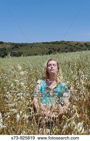 Stock Photo - Woman sitting on a field of Naxos, Cyclades Islands, Greece. Fotosearch