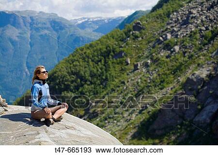 Woman sitting on a rock. Hordaland. Norway. View Large Photo Image Stock Image - Woman sitting on a rock. Hordaland. Norway.. Fotosearch