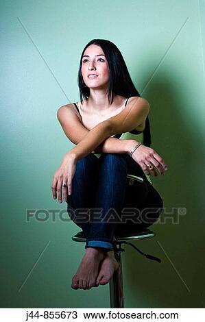 Stock Image - Woman sitting on an office chair, smiling portrait. Fotosearch