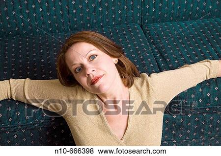 Woman sitting on her sofa. View Large Photo Image Stock Photo - Woman sitting on her sofa.. Fotosearch