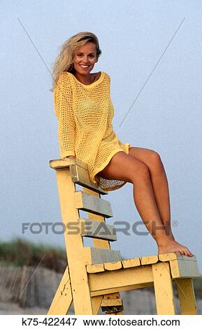 Stock Photo - Woman sitting on lifeguard chair. Fotosearch