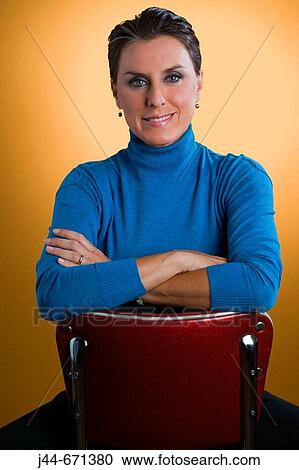 Woman sitting on red chair with yellow background, portrait View Large Photo Image Stock Image - Woman sitting on red chair with yellow background, portrait. Fotosearch