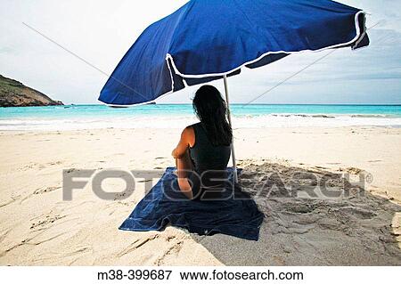 Woman sitting under an umbrella on Saline Beach, St. Barts View Large Photo Image Stock Photo - Woman sitting under an umbrella on Saline Beach, St. Barts. Fotosearch