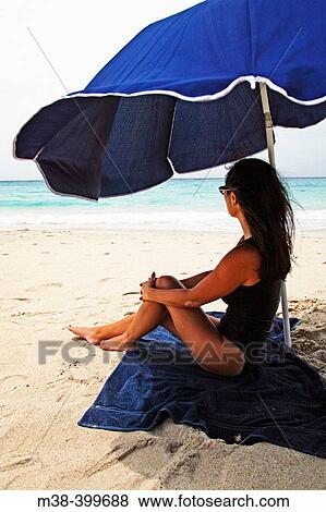 Woman sitting under an umbrella on Saline Beach, St. Barts View Large Photo Image Stock Photo - Woman sitting under an umbrella on Saline Beach, St. Barts. Fotosearch