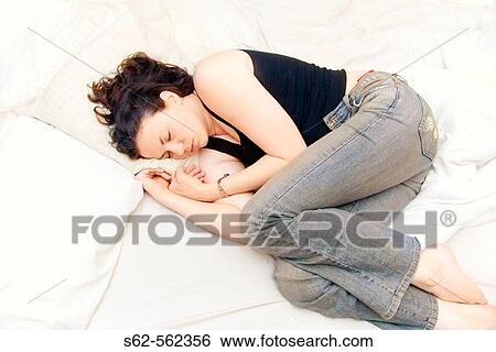 Woman sleeping in clothes on bed View Large Photo Image Stock Photograph - Woman sleeping in clothes on bed. Fotosearch