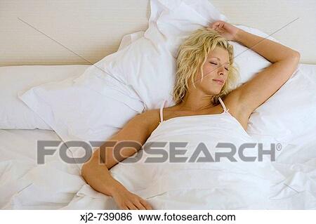 Stock Photograph - Woman sleeping in the bed. Fotosearch
