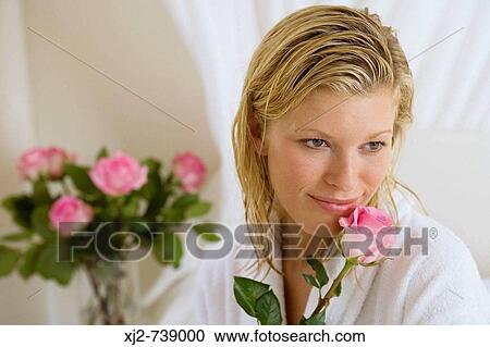 Woman smelling a flower View Large Photo Image Stock Image - Woman smelling a flower. Fotosearch