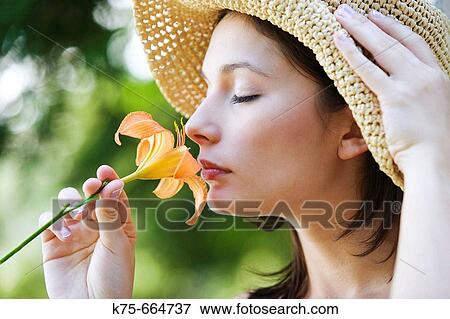 Stock Photo - Woman smelling lily. Fotosearch