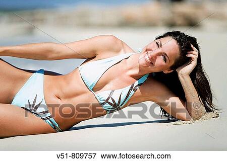 Woman smiling laying by the sea View Large Photo Image Stock Photo - Woman smiling laying by the sea. Fotosearch